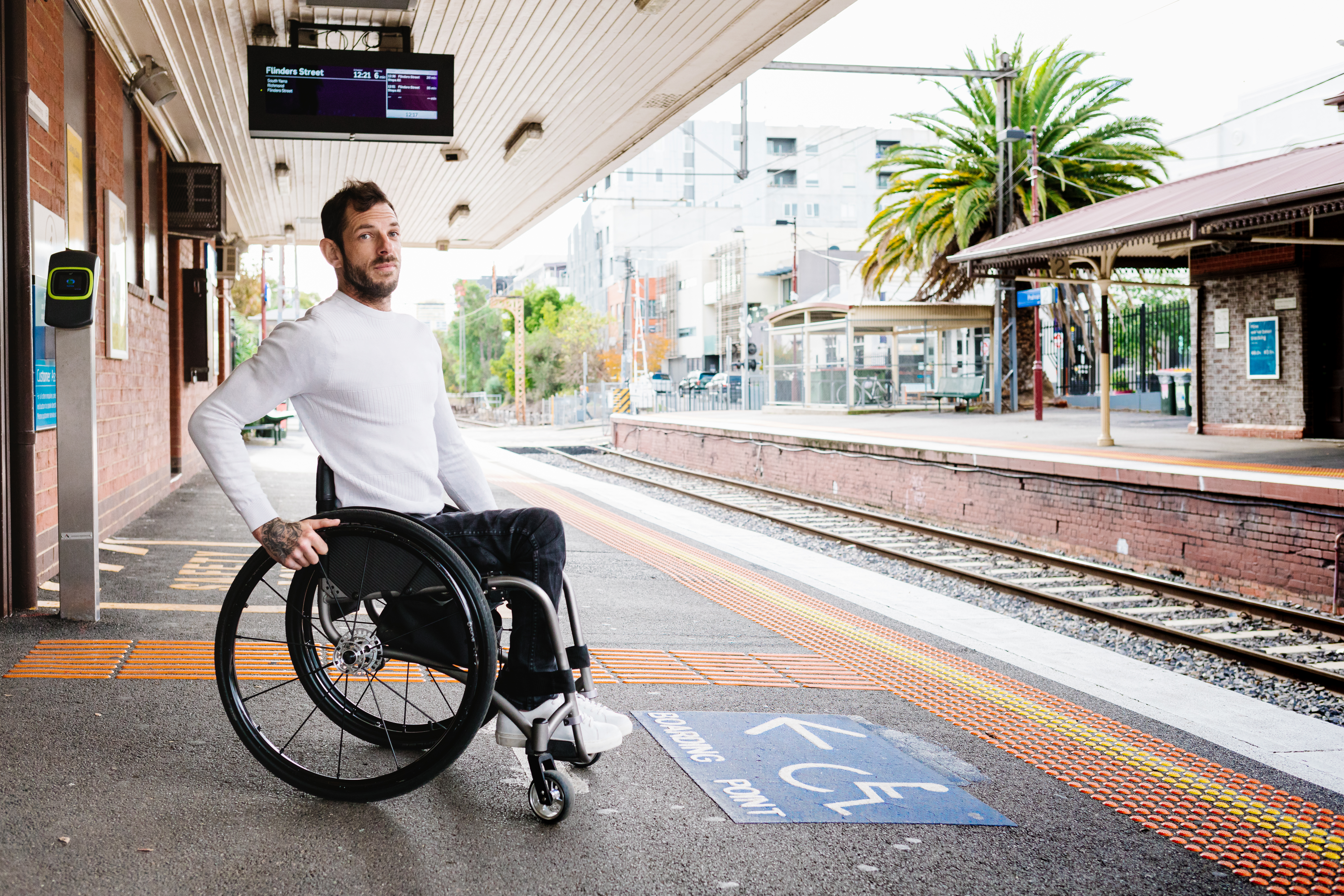 Man who is a wheelchair user waiting at the train platform Man who is a wheelchair user waiting at the train platform