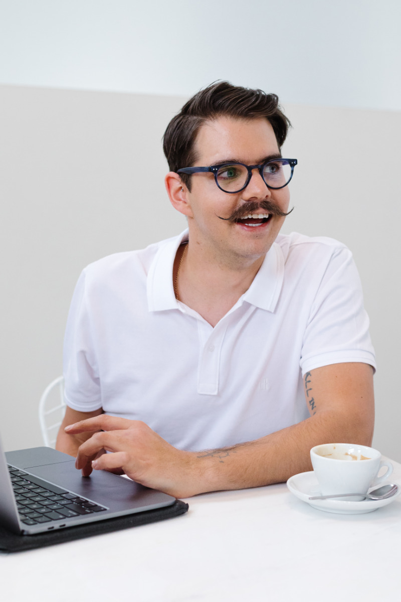 Man sitting at table in laptop smiling Man sitting at table in laptop smiling