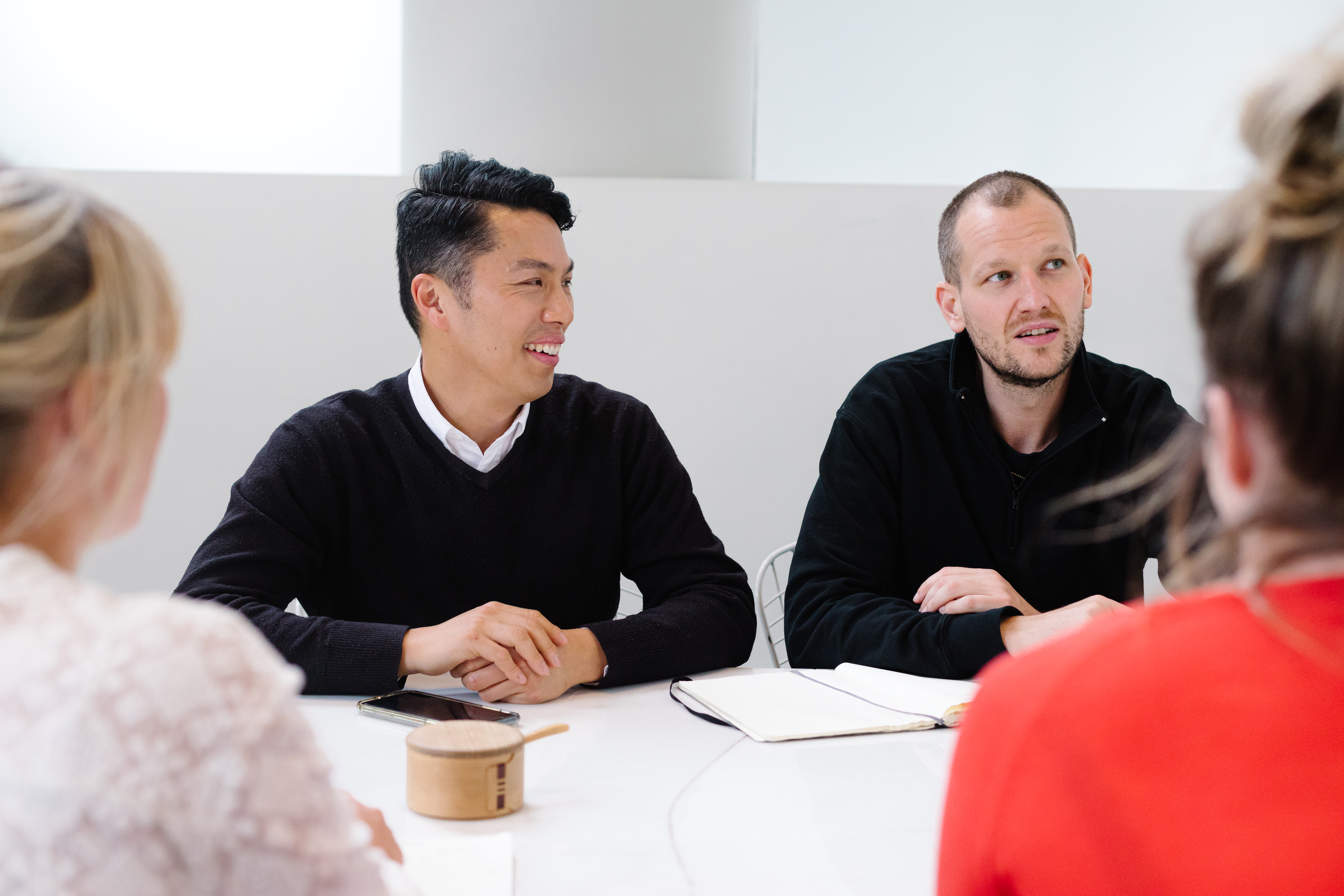 Man sitting at table looking at colleagues smiling