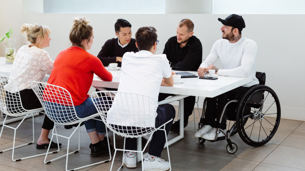 Group of GSA associates chatting around a meeting table.