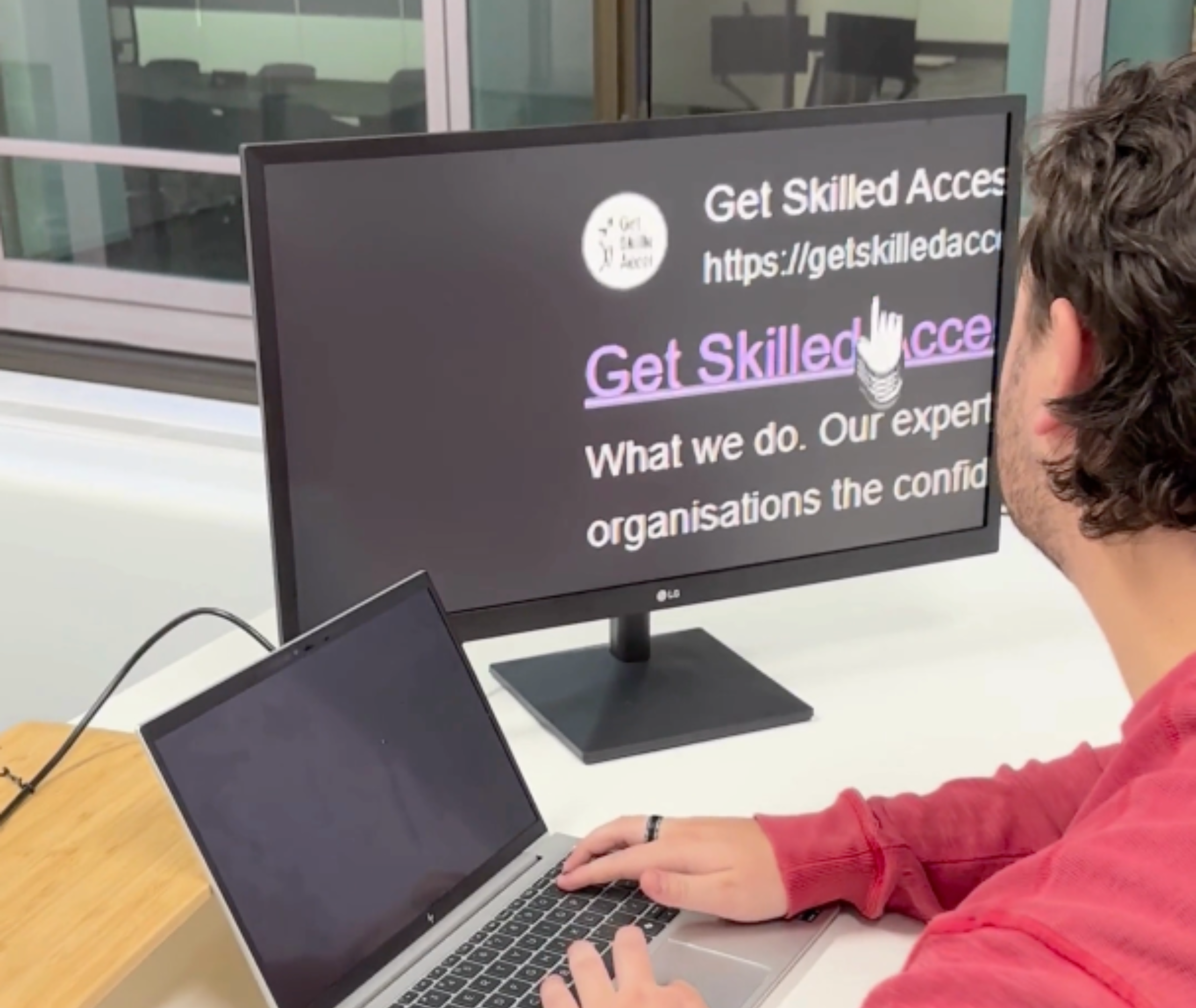 A person working on his computer. He is using the Zoom in feature to see the text on screen.