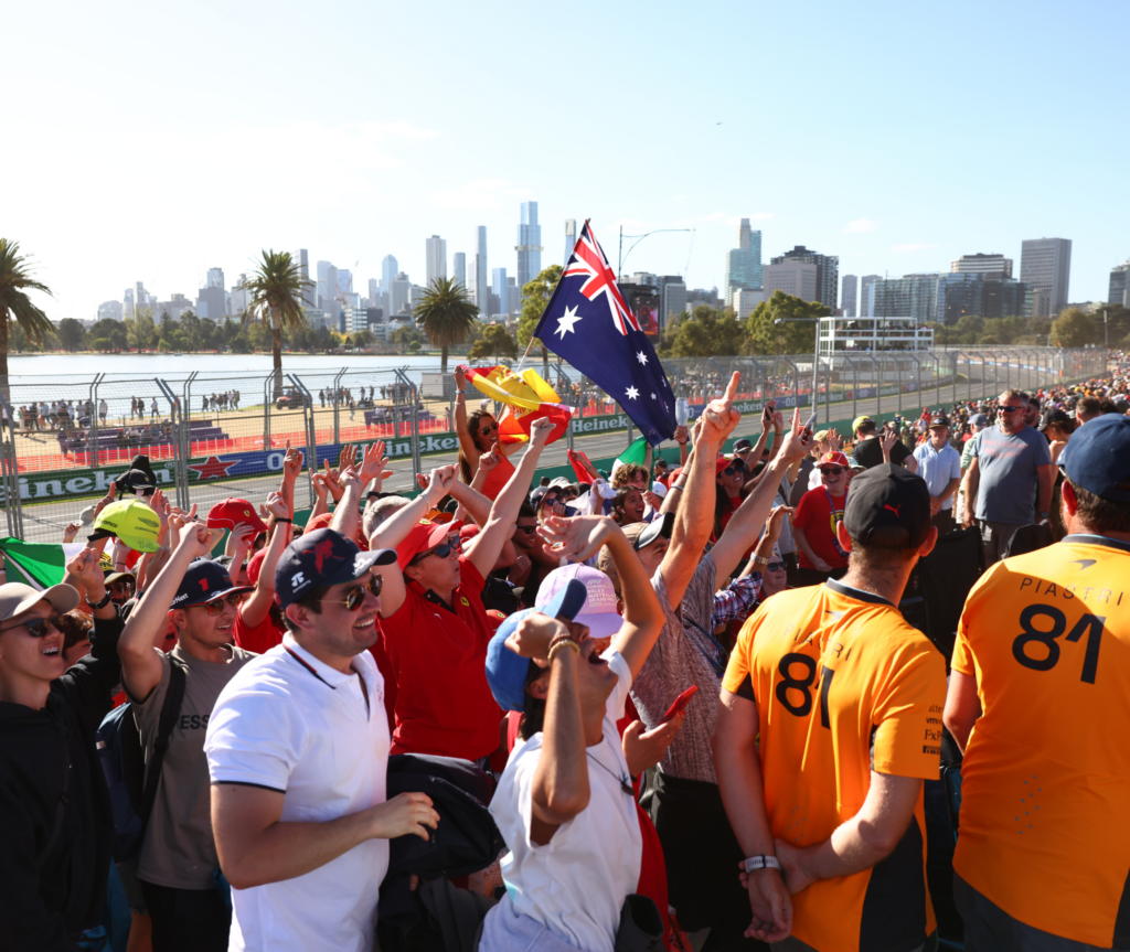F1 fans celebrating at a race event, one with an Australian flag.
