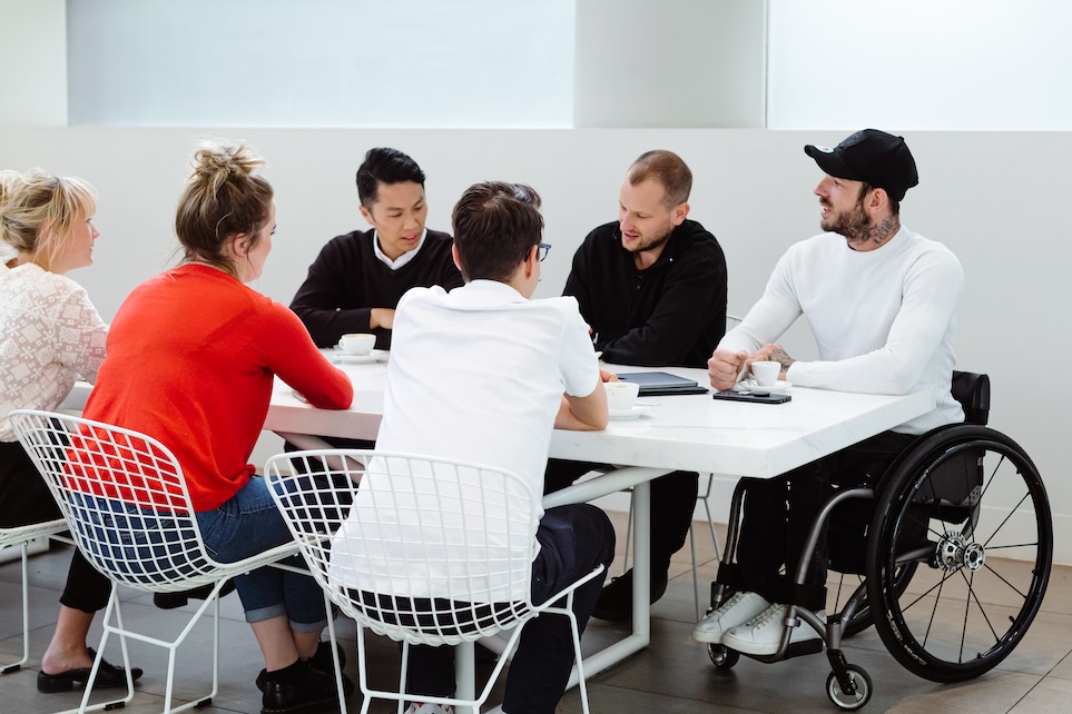 A group of people gathered around a table and talking.