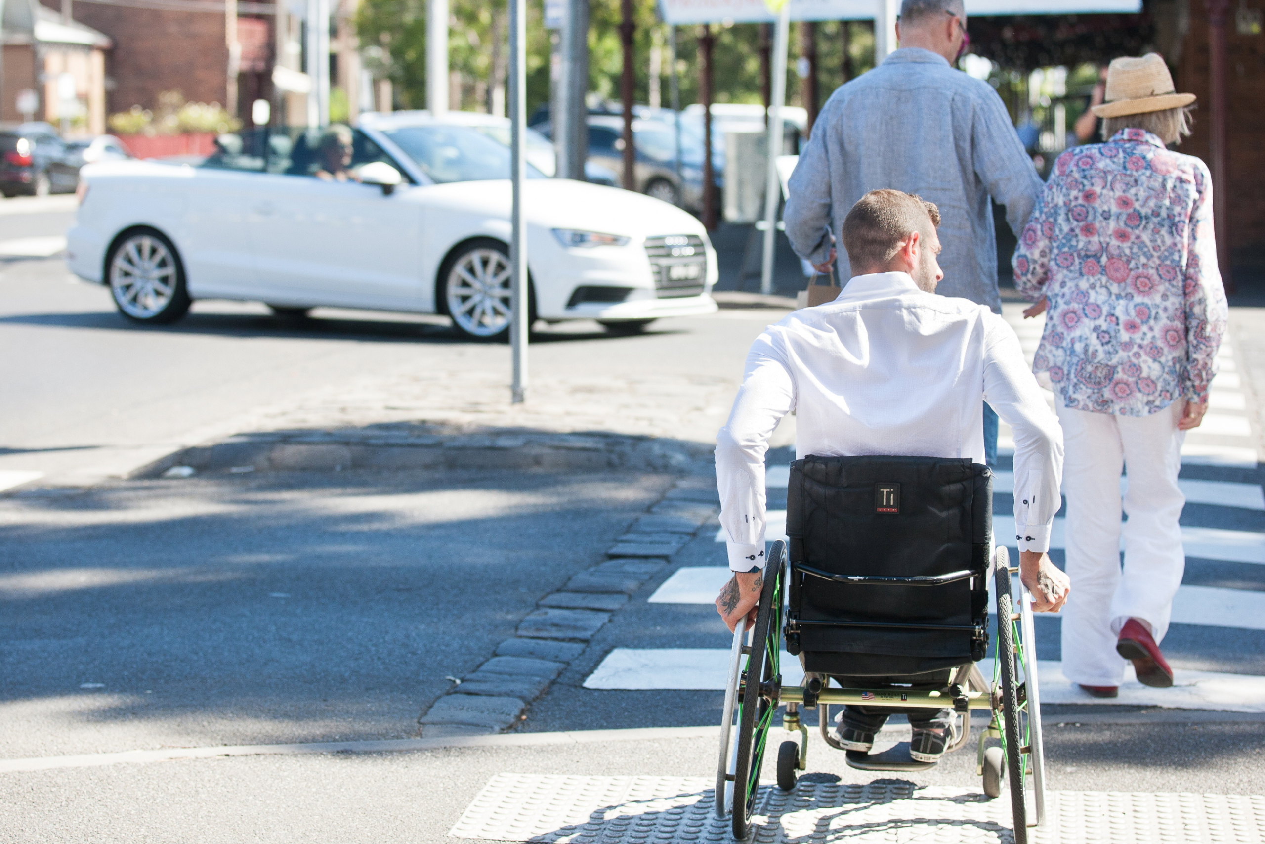 A man on wheelchair crossing a street.