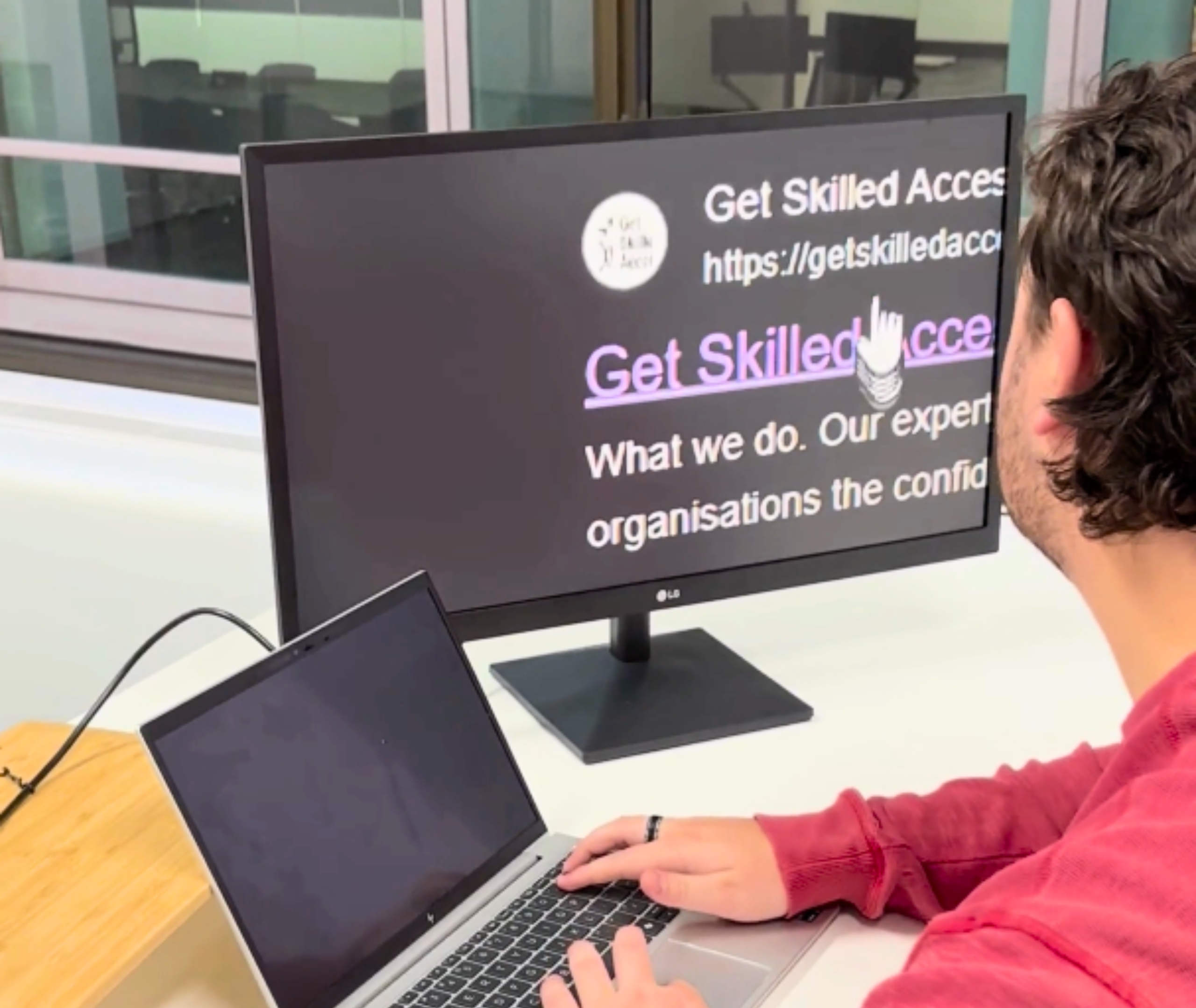 Someone using a computer monitor. The magnifier is used on the screen looking at Get Skilled Access website.