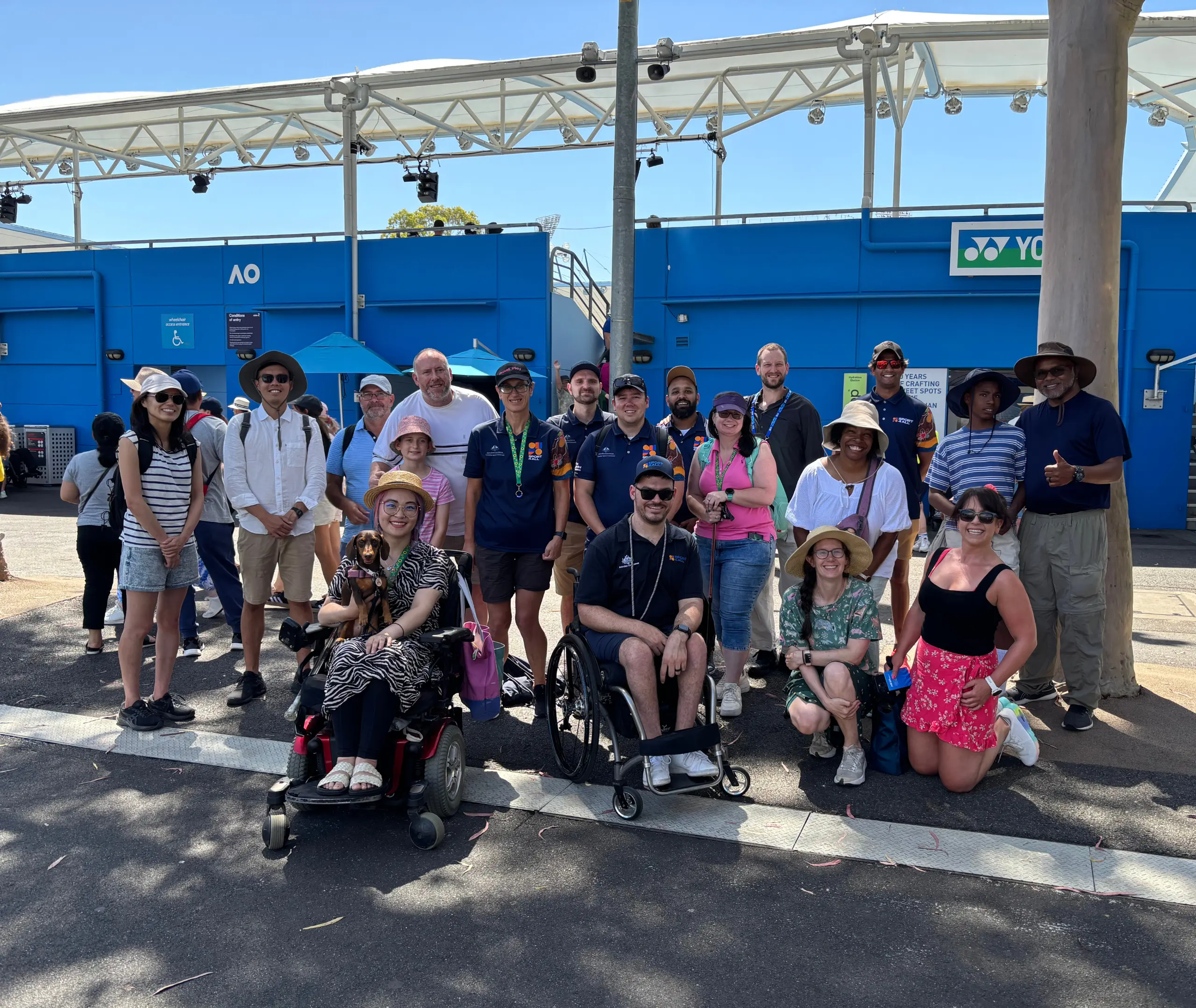 Group photo of the Sport4All team with guests and attendees at the Sport4All activation during AO 2025. Everyone is looking at the camera.