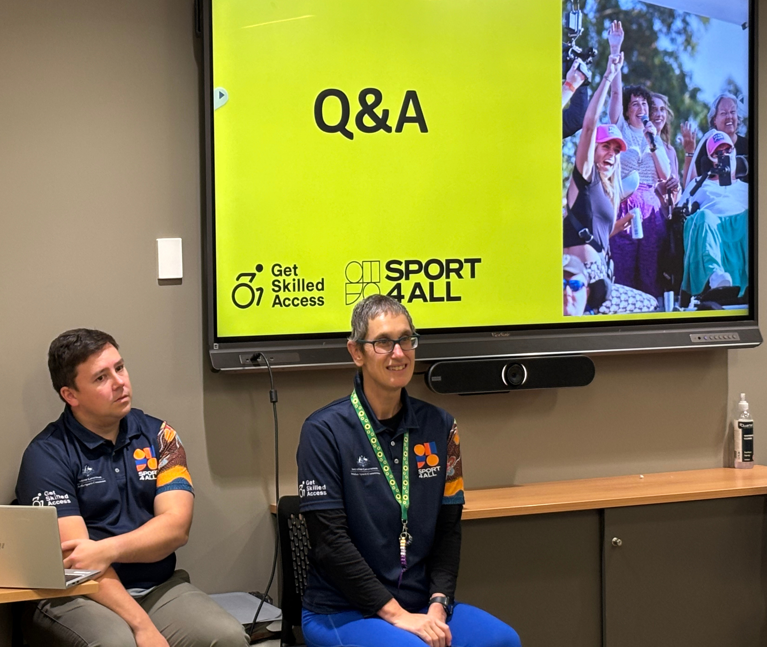 Two presenters in Sport4All shirts seated in front of a large screen displaying a yellow slide that reads “Q&A” with Get Skilled Access and Sport4All logos.