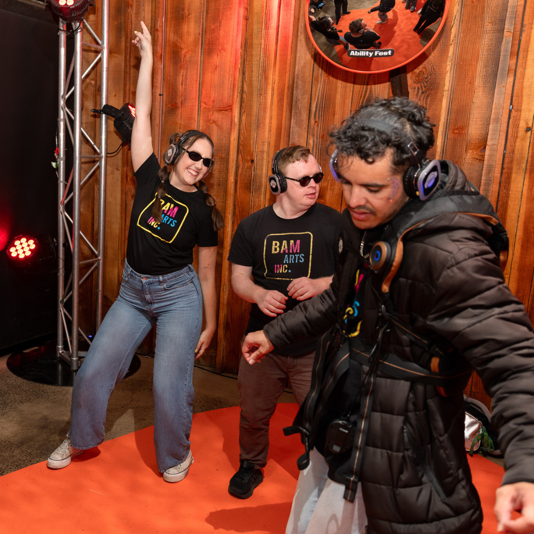 Three people dancing with headphones at a silent disco.